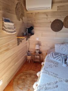 a bedroom with wooden walls and a bed and a table at L'écureuil perché in Apt