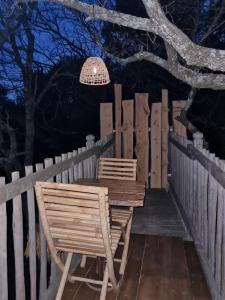 a table and two chairs on a deck at night at L'écureuil perché in Apt