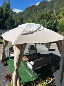 a white umbrella on a patio with chairs and a table at Chez Ava in Salazie