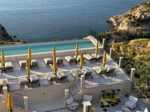 a balcony with tables and yellow umbrellas and a pool at Gran Hotel Margalida by Annua Signature in Banyalbufar