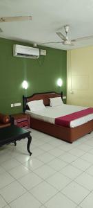 a bedroom with a large bed and green walls at Bluemoon Hotel in Cochin