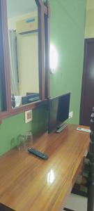 a computer on a wooden desk with a mirror at Bluemoon Hotel in Cochin