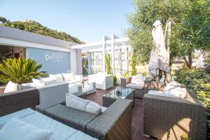 an outdoor patio with couches and an umbrella at Sunny Days Hotel in Ixia