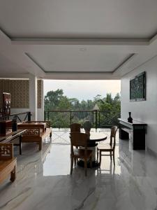 a living room with a table and chairs and a balcony at Casa De Brillo Tegallalang in Tegalalang