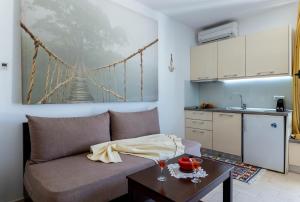 a living room with a couch and a kitchen at Alex port view apartments in Syvota