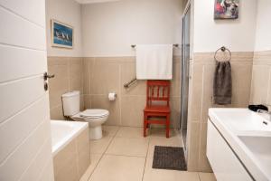 a bathroom with a toilet and a tub and a sink at Die Koraalbos in Stilbaai-Oos +10 photos