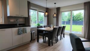 a kitchen and dining room with a table and chairs at Villapark Wulpdal | Villa De Wulp in Scherpenisse