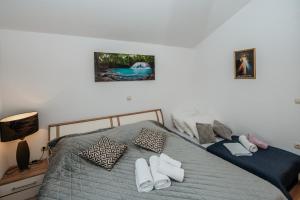 a bedroom with a bed with slippers on it at Apartmani Saric A&K in Vir