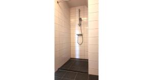 a shower stall in a bathroom with white tiles at Villapark Wulpdal | Villa De Wulp in Scherpenisse +28 photos