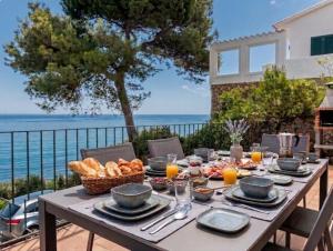 a table with food on it with a view of the ocean at La Terrasse 1-Vue Mer Panoramique & Piscine, BBQ in Begur