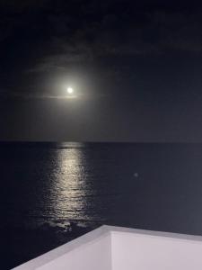 a full moon over the ocean at night at HERO VILLA ocean suite in Ishigaki Island