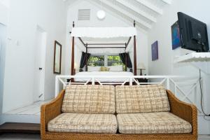 a living room with a couch in front of a bed at Oualie Beach Resort in Nevis