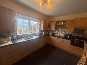 a large kitchen with a sink and a window at The Cloverhill House in Mullaghbane