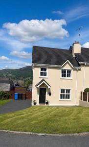 a white house with a grassy yard at The Cloverhill House in Mullaghbane