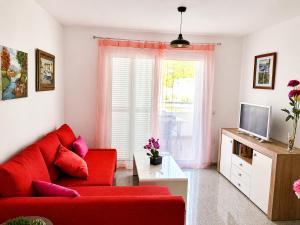 a living room with a red couch and a tv at Velez Nazari Cambriles in Lújar