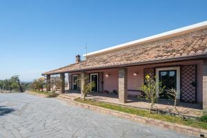 a brick building with a driveway in front of it at Oasi Orange Villa with Jacuzzi in Paterno
