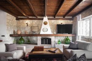 a living room with a stone fireplace and a tv at Oasi Orange Villa with Jacuzzi in Paterno