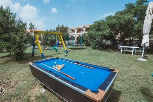 a pool table in a yard with a playground at Apartmani Saric A&K in Vir