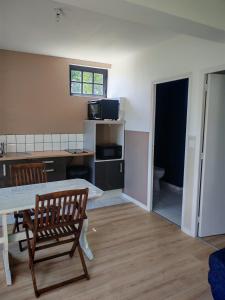 a kitchen and dining room with a table and chairs at Studio indépendant tout équipé proche circuit des 24 Heures in Teloché