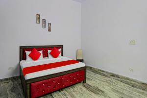 a bedroom with a bed with red pillows at Hotel O Rest & Zone Hotel in Greater Noida