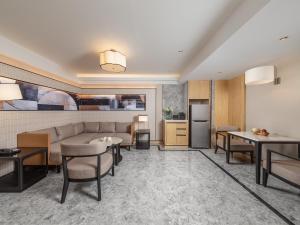a living room with a couch and tables and a kitchen at Samala Suites Bangkok Sukhumvit 19 by Kingston Hotels in Bangkok