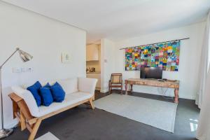 a living room with a white couch and blue pillows at Kochab Comporta in Comporta