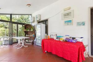 a kitchen with a red table with a refrigerator at Agriturismo La Fredda in Sommacampagna +70 photos