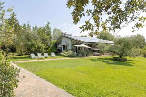 a house with a lawn and chairs in the yard at Agriturismo La Fredda in Sommacampagna