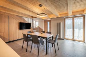a dining room with a wooden table and chairs at Casera Malvan, private wellness chalet in Belluno +14 photos