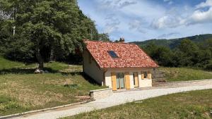 a small house with a red roof on a hill at Casera Malvan, private wellness chalet in Belluno