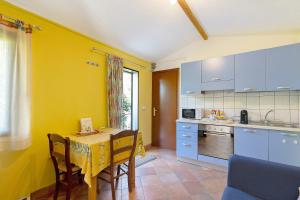 a kitchen with a table and a yellow wall at Agriturismo La Fredda in Sommacampagna