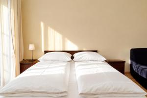 two beds in a bedroom with white sheets and pillows at HORN Jastarnia in Jastarnia
