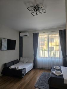 a bedroom with a bed and a couch and a tv at Turmhaus Hermannstadt in Sibiu