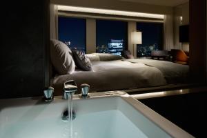 a bathroom with a large bed and a bath tub at Keio Plaza Hotel Tokyo in Tokyo