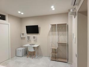 a white room with a table and a tv on the wall at Terraforte Luxury Suite in Fisciano