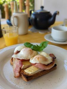a breakfast sandwich with eggs on a plate on a table at Applecroft House in Killarney +23 photos