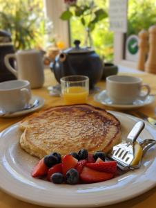 a plate with pancakes and fruit on a table at Applecroft House in Killarney