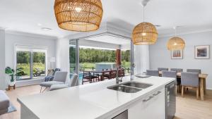 a kitchen and living room with a table and chairs at Kokoon in Pokolbin