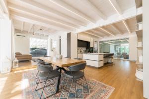 a kitchen and dining room with a wooden table and chairs at Luxury Home & Pool by Symphonya Luxury Holiday Rentals in Lequile