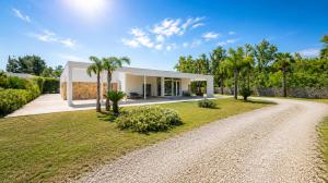 a villa with a driveway and a house at Luxury Home & Pool by Symphonya Luxury Holiday Rentals in Lequile
