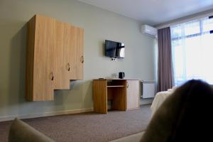 a living room with a cabinet and a television at Hotel Zich in Kobuleti