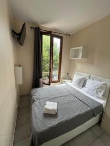 a bedroom with a large bed with a window at myappart - La Garenne in La Garenne-Colombes