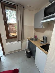 a small kitchen with a sink and a window at myappart - La Garenne in La Garenne-Colombes