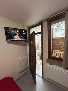 a room with a flat screen tv on the wall at myappart - La Garenne in La Garenne-Colombes