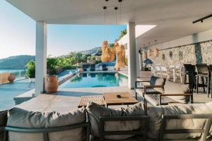 a living room with a pool with chairs and a table at Michelle Villa in vlicha +66 photos