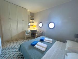 a bedroom with a bed with towels and a desk at Villa Azzurra in Conca dei Marini +47 photos