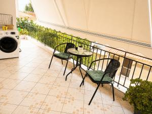 a balcony with a table and chairs and a washing machine at Eva's House in Amarynthos
