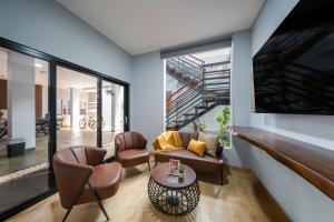 a living room with two chairs and a table at Cove Good Friends in Busuk 1