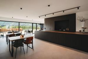 a dining room with a bar with tables and a tv at New Opening Grafferhof in Bolzano
