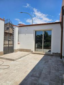 a white house with a gate and a patio at Teseo Holiday in Castelvetrano Selinunte +2 photos